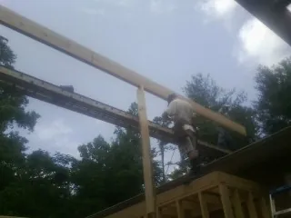 Carpenter setting a ridge beam over a new addition frame — Ice Dam Removal by Roofing Brothers in Rockbridge