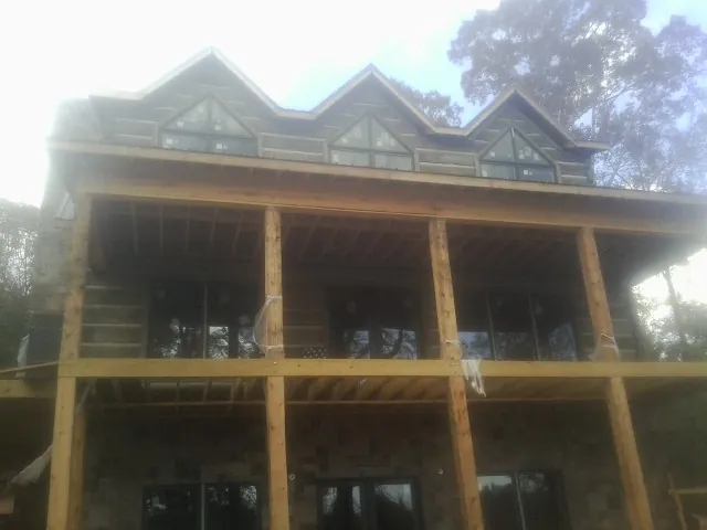 Dormers and porch framing on a large log home under construction — Roof Coating work by our crew in Rockbridge