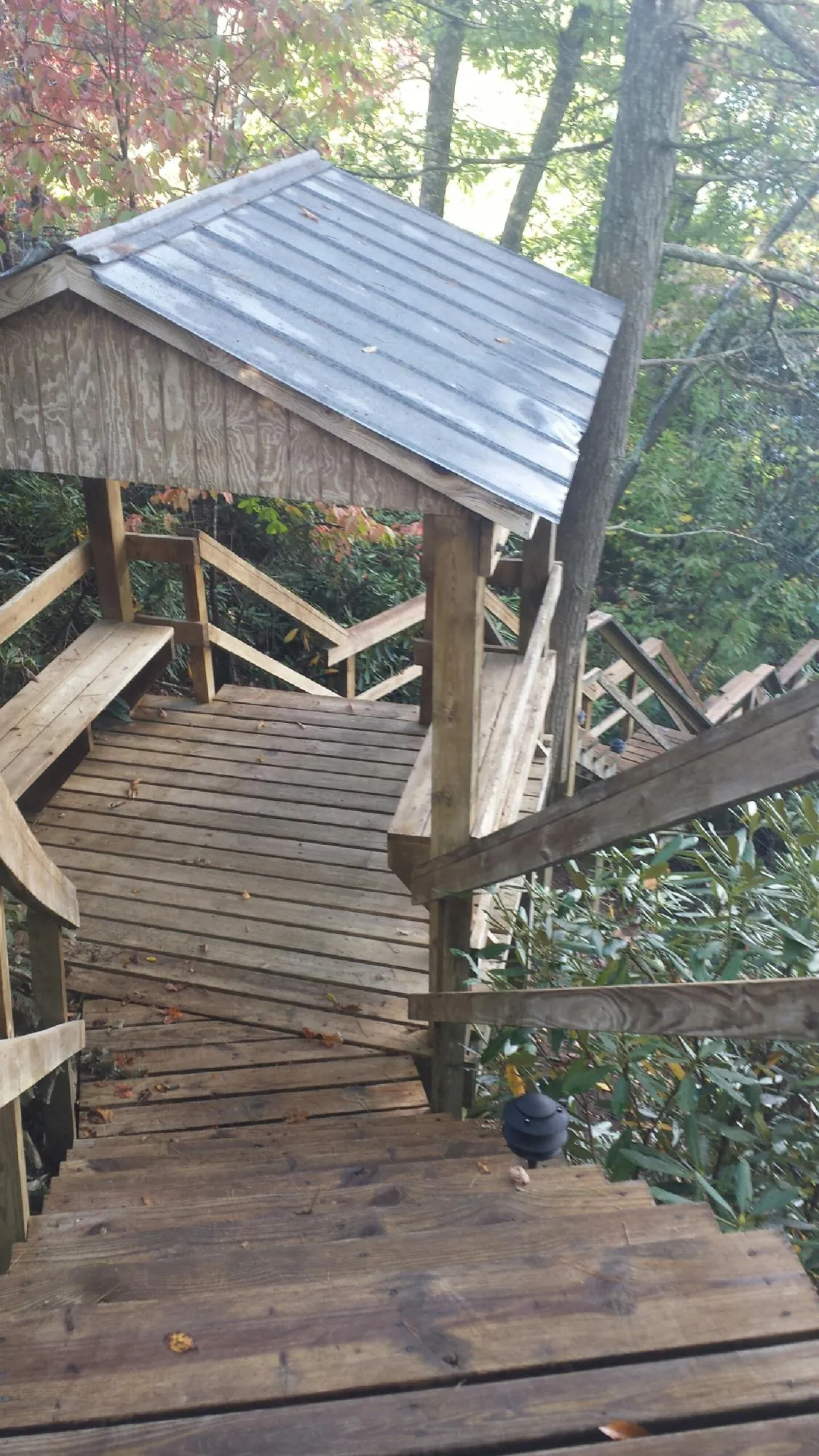 Metal roofed shelter over wooden steps on a wooded walkway — Skylight Repair & Installation work by our crew in Rockbridge