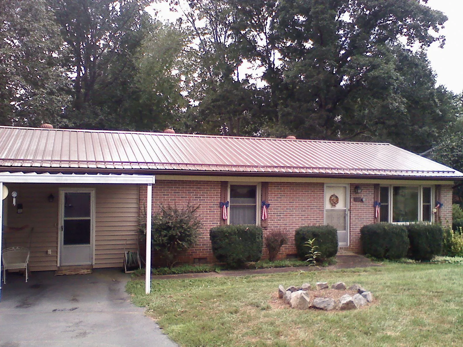 Bronze metal roof and carport on a brick ranch home — Roof Repair work by our crew in Rockbridge